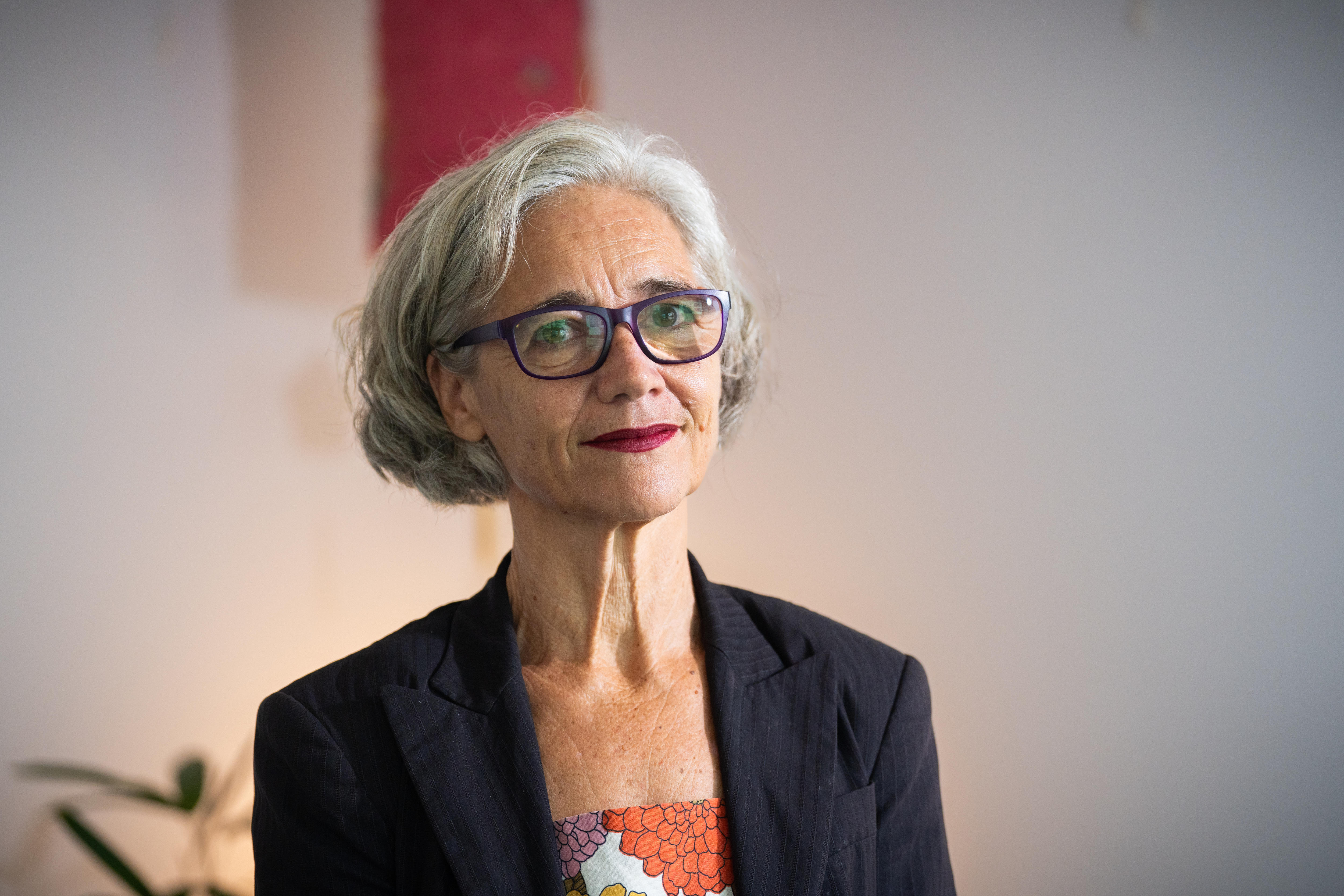 A woman in a dark blazer and orange dress