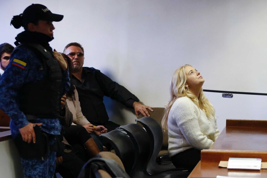 Cassie Sainsbury sits in court looking up to the ceiling as her family sits behind her.