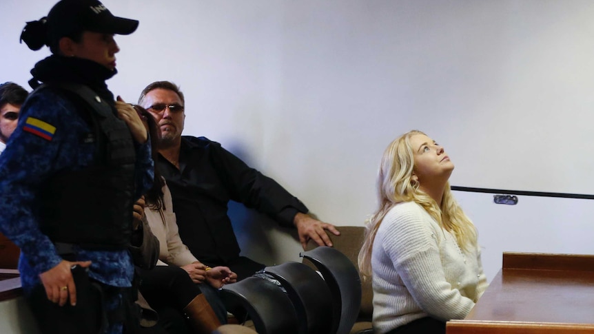 Cassie Sainsbury sits in court looking up to the ceiling as her family sits behind her.
