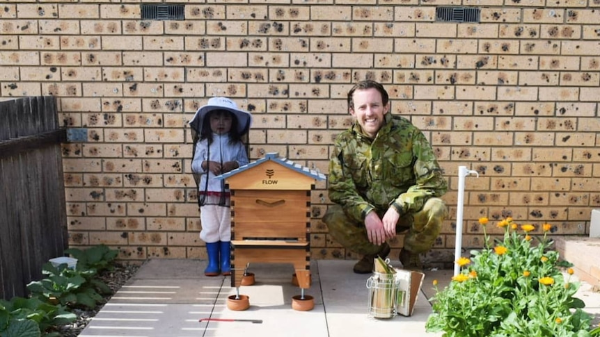 Mike Lewi and Dominique in their backyard standing near their hive.