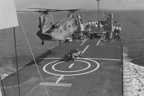 A RAAF Chinook C-47A preparing to lift an Army Land Rover from Tobruk's forward flight deck.