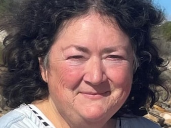 A woman with brown hair wearing a white shirt