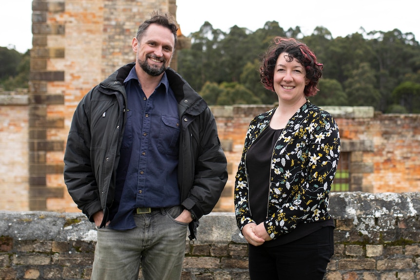 A man and woman stand near the walls of ruins at the historic Port Arthur penal colony. 