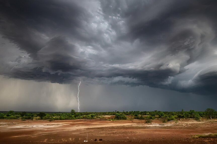 A Kimberley landscape with storm clouds above and a lightning bolt hitting the ground