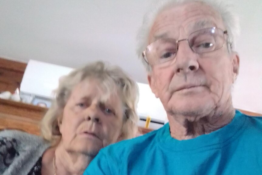 An older man and a woman huddled together for a selfie.