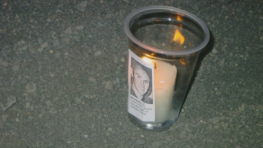 A candle with a photo of Bali bombing victim Billy Hardy attached