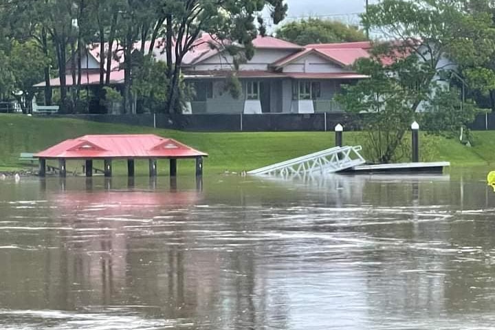 Buildings and a jetty submerged in water.