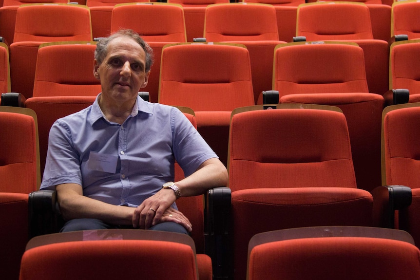 Robert Forgács sits in a University of Sydney lecture theatre