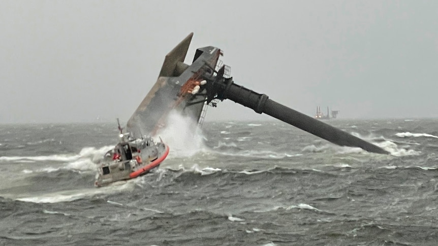 A Coast Guard boatcrew heads towards a capsized commercial vessel in search of survivors.