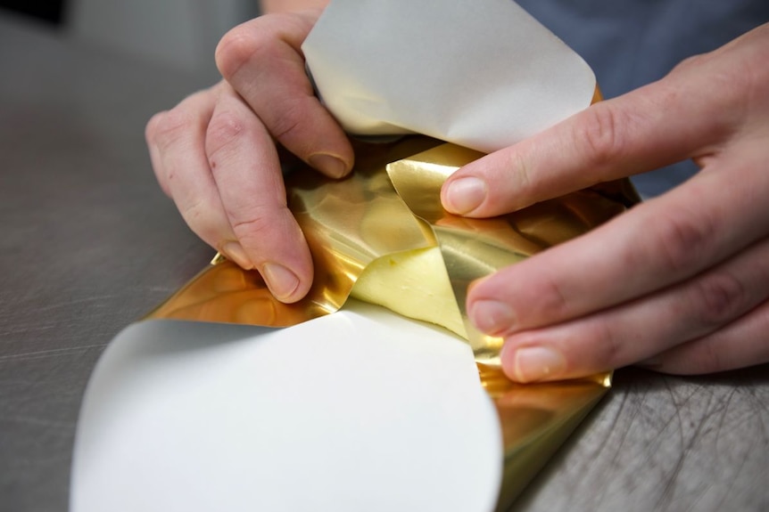 Butter being wrapped in foil.