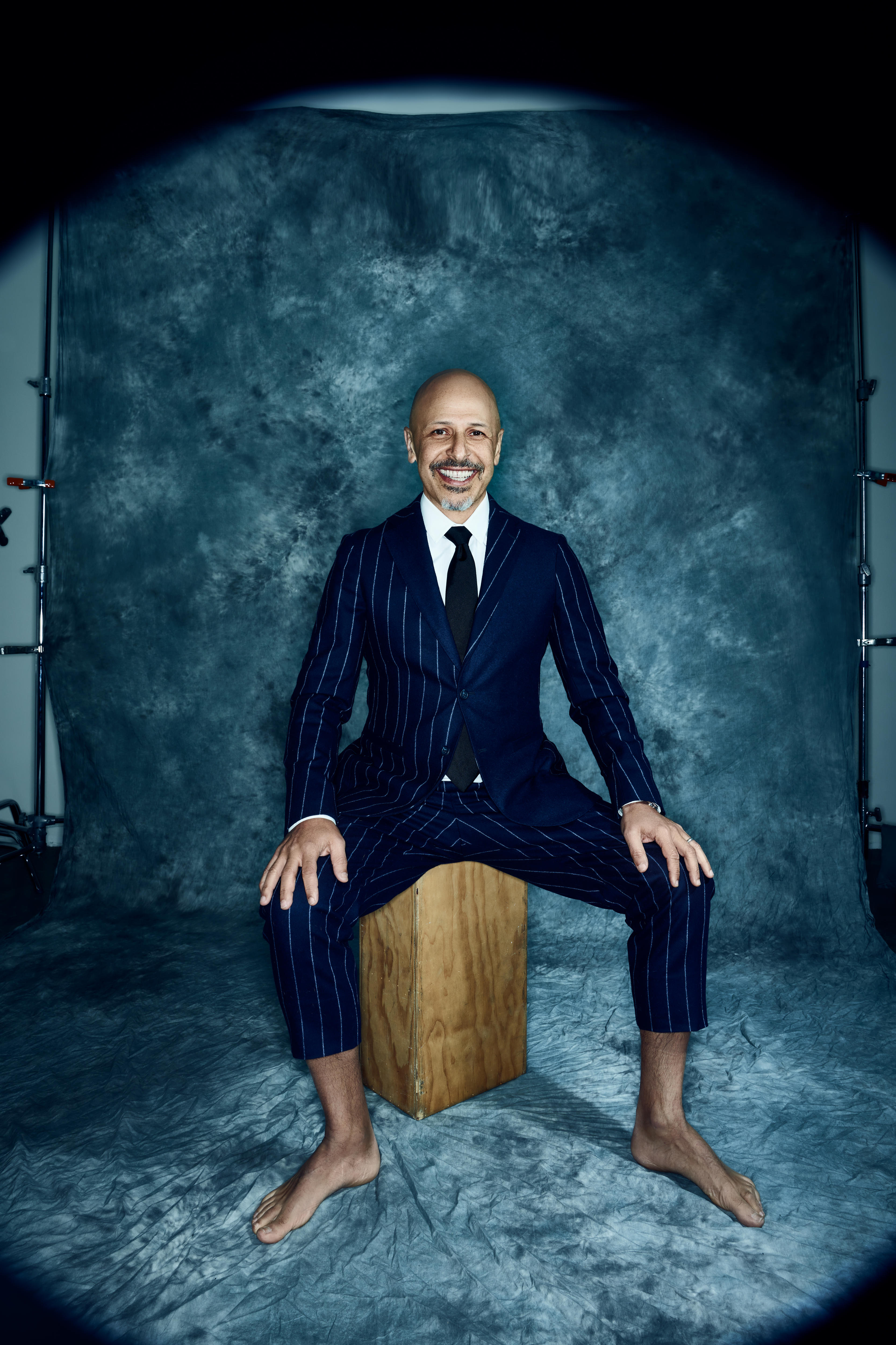 A man in pinstripe suit and no shoes 