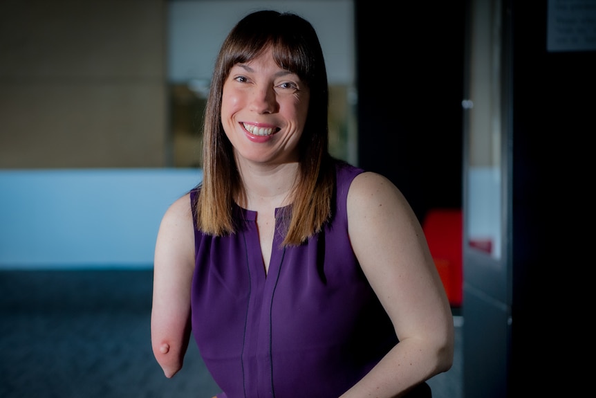 A smiling woman with limb difference 