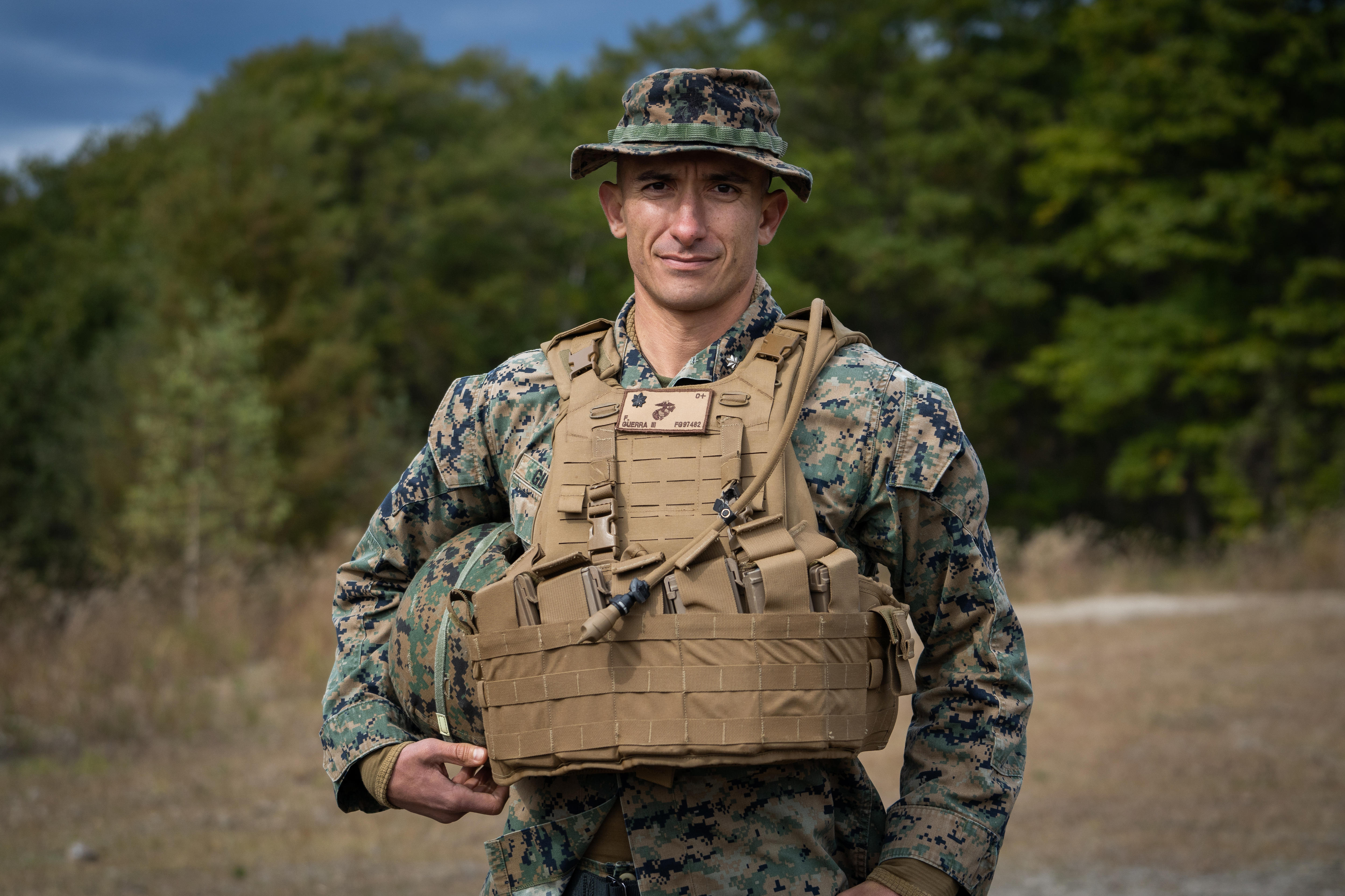 A soldier in army fatigues and a khaki vest 
