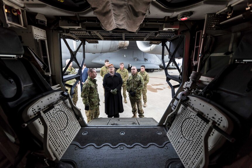 View from inside a Boxer CRV looking through the open door at Marise Payne and six uniformed soldiers