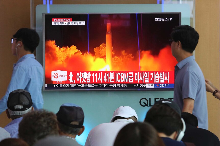 People watch a TV report in Seoul of North Korea's latest test launch of an ICBM.