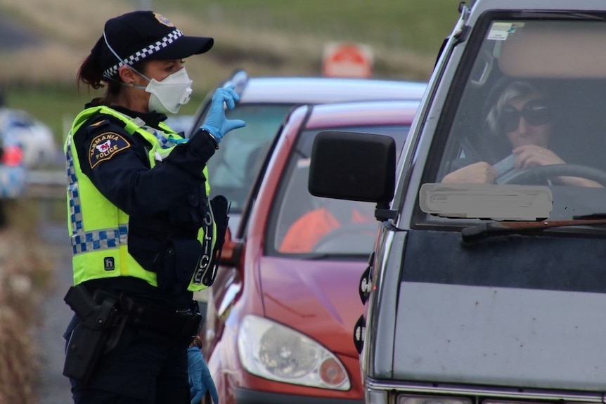 Female Tasmanian Police officer wearing respiratory mask conducting roadside stop.
