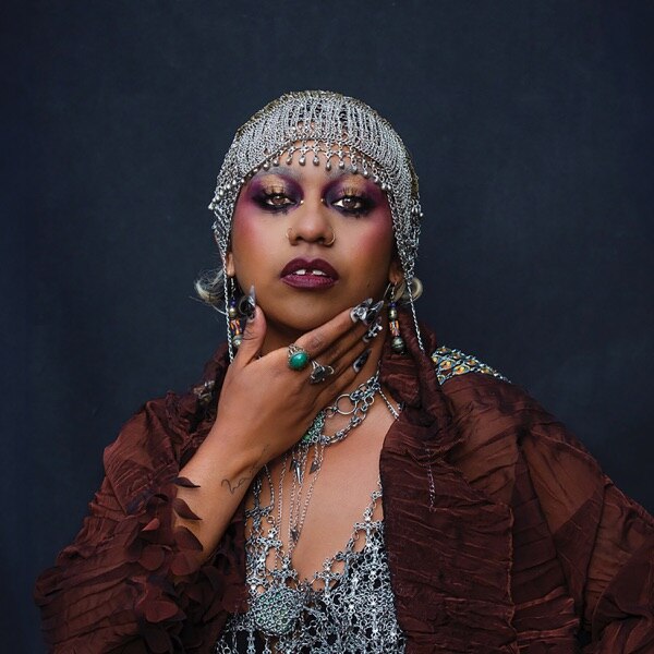 Singer Emily Wurramara wears head jewels and has hand on her chin