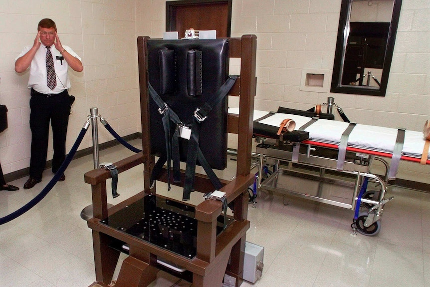 A warden stands next to an electric chair at Riverbend Maximum Security Institution in Nashville, Tennessee in 1999.