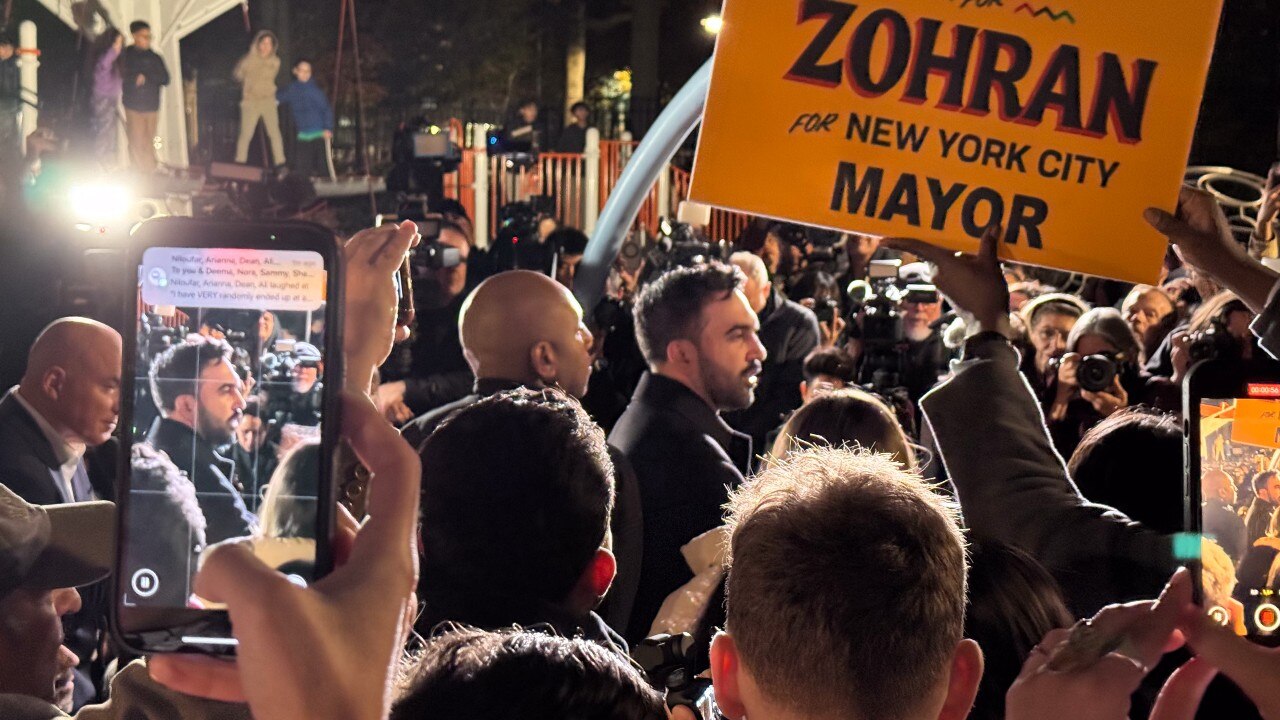 A man in a suit surrounded by a crowd.