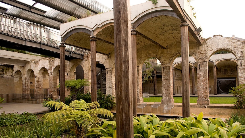 You look up at through open-air vaults of a Victorian brick reservoir, with verdant green landscaping in the foreground.