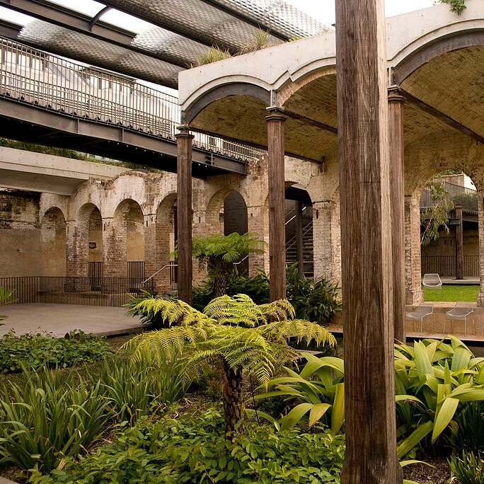 You look up at through open-air vaults of a Victorian brick reservoir, with verdant green landscaping in the foreground.