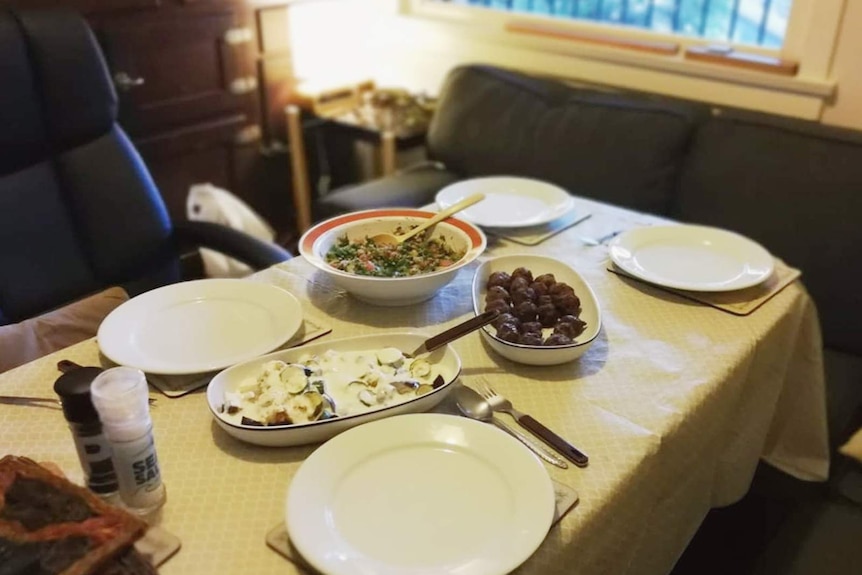 Kofte meatballs, kisir (Turkish tabouli) and fried cauliflower in garlic yoghurt on a dining table.