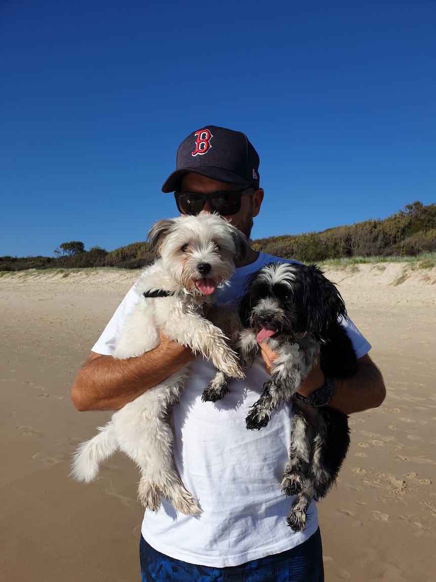 Travis holds Bill and Peppa the dogs