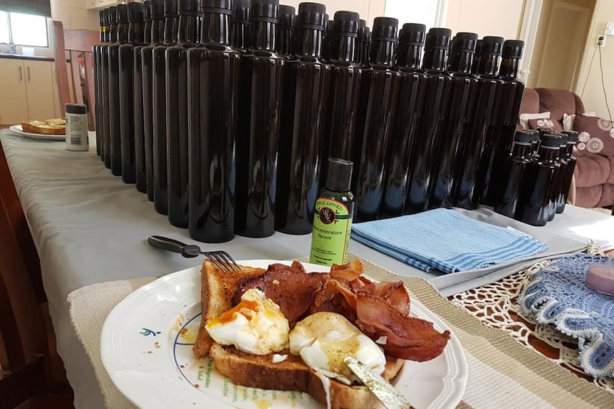 Bacon eggs with a pile of sauce bottles behind.
