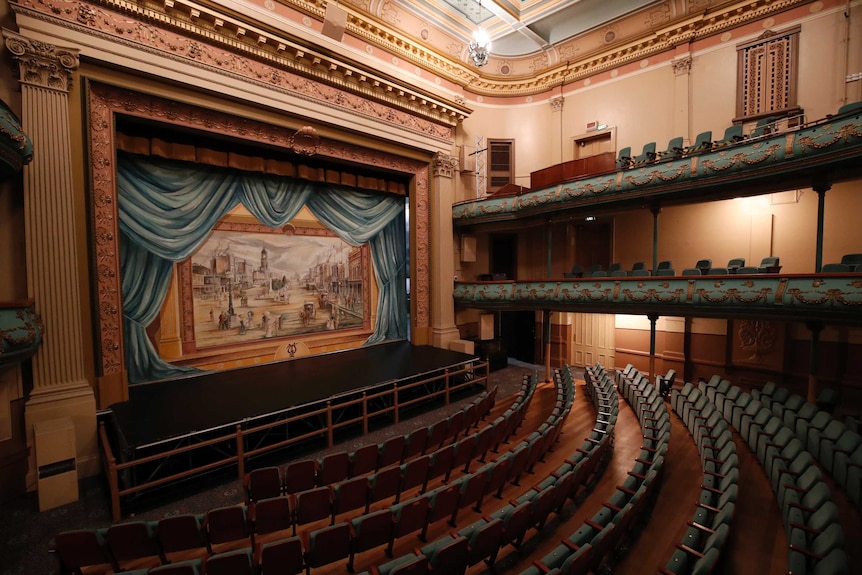 A view toward the stage from the audience inside a historic theatre.