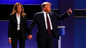 Donald Trump gives a 'thumbs up' while holding hands with Melania Trump.
