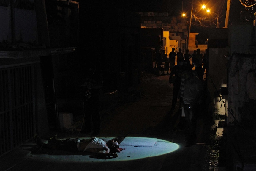 The body of Rogelio Gilbuena, 56, lies at the Navotas Public Cemetery, hours after being abducted from his home.