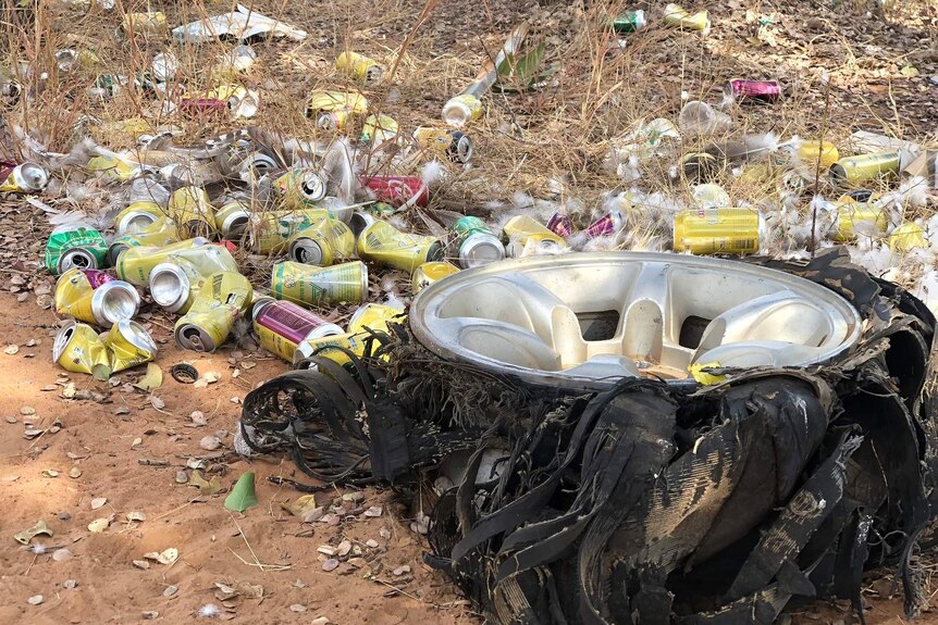 A busted tyre framed by littered alcohol cans at Doomadgee.