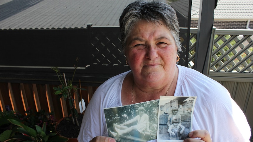 Cheryl Bihari holding black and white photos from her childhood.