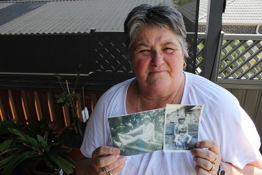 Cheryl Bihari holding black and white photos from her childhood.