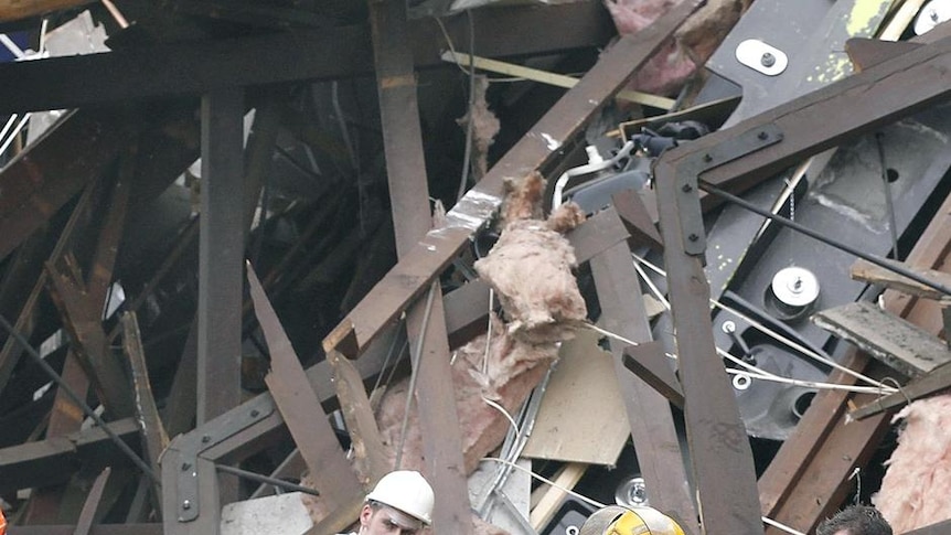 Rescuers stop to listen for sounds from survivors in a collapsed building