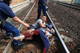 Hungarian policemen stand by the family of migrants