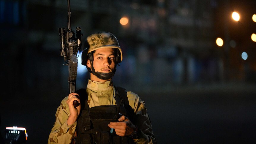 Afghan special forces soldier stands guard near of Serena hotel