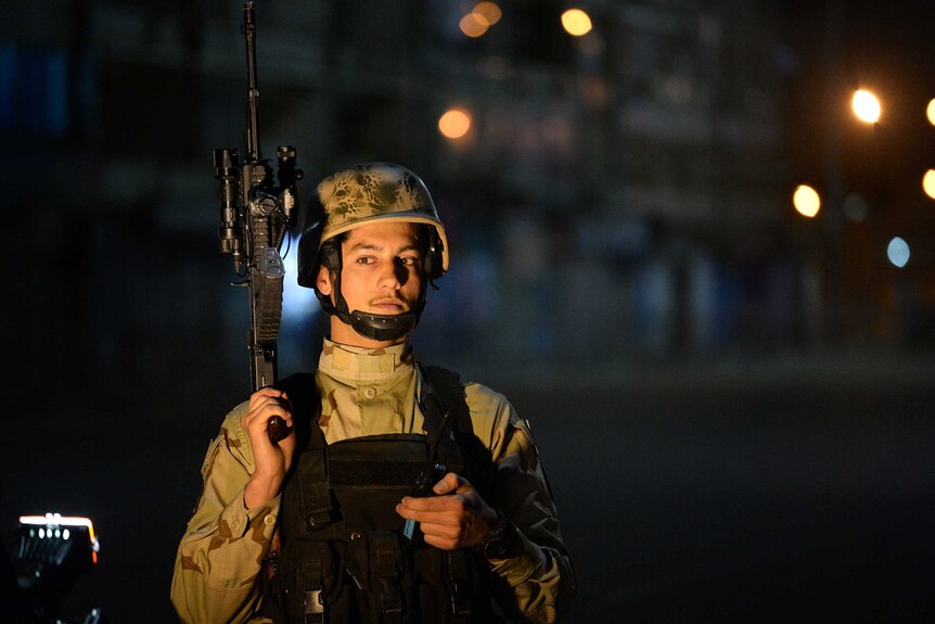 Afghan special forces soldier stands guard near of Serena hotel