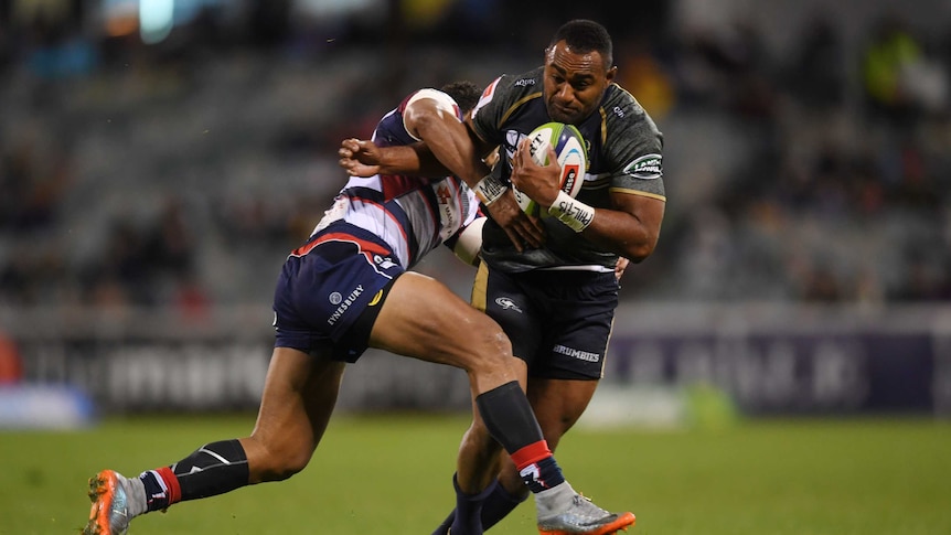 The Brumbies' Tevita Kuridrani is tackled by the Rebels' Sefa Naivalu