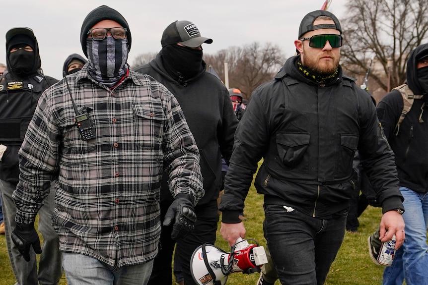 Proud Boys members Joseph Biggs (L), and Ethan Nordean (R) with megaphone, walk toward the US Capitol.