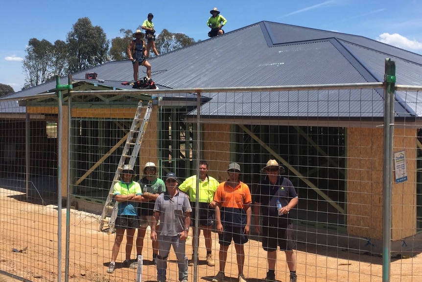 Builders standing outside Nick's Journey House during construction