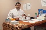 Dorrigo Pharmacist Sri Popuri sitting in front of vaccines 