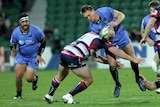 Western Force player  Dane Haylett-Petty is tackled from the side by a Melbourne Rebels player while carrying a rugby ball.