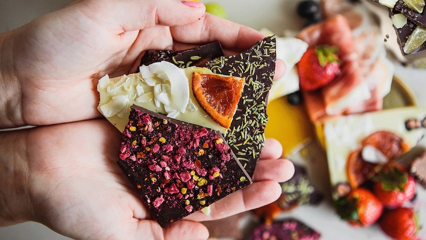 A colourful array of chocolates in someone's hands.