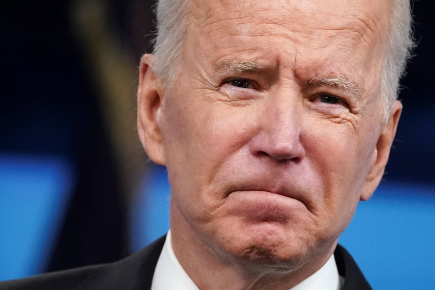 A close-up of US President Joe Biden, frowning 