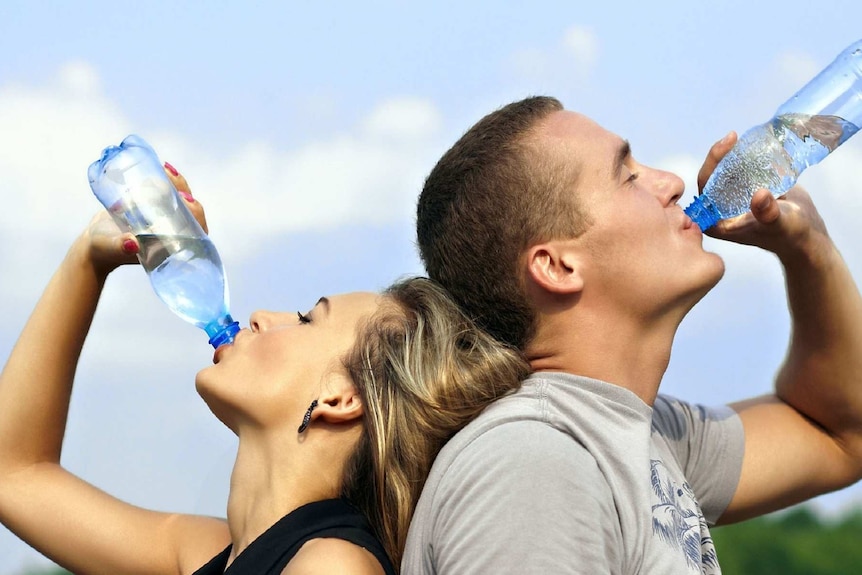 Two people drinking bottle water