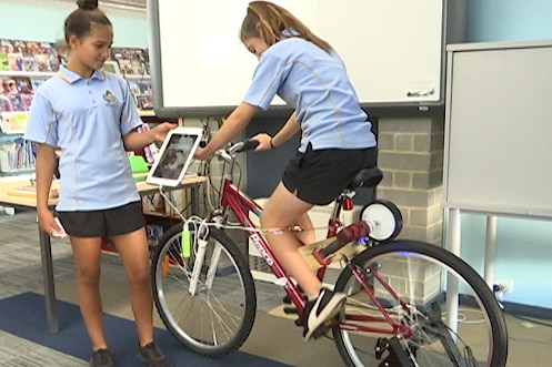 Students at Newton Moore ride a bike phone charger