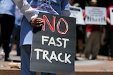 Demonstrator holds sign protesting Trans-Pacific Partnership fast track