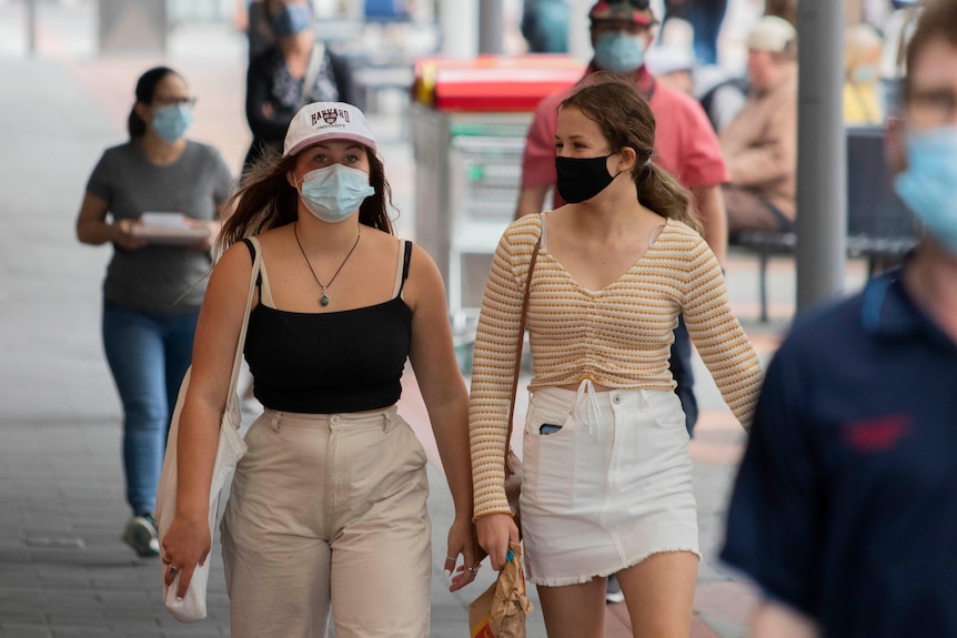 People on the street wearing a mask.