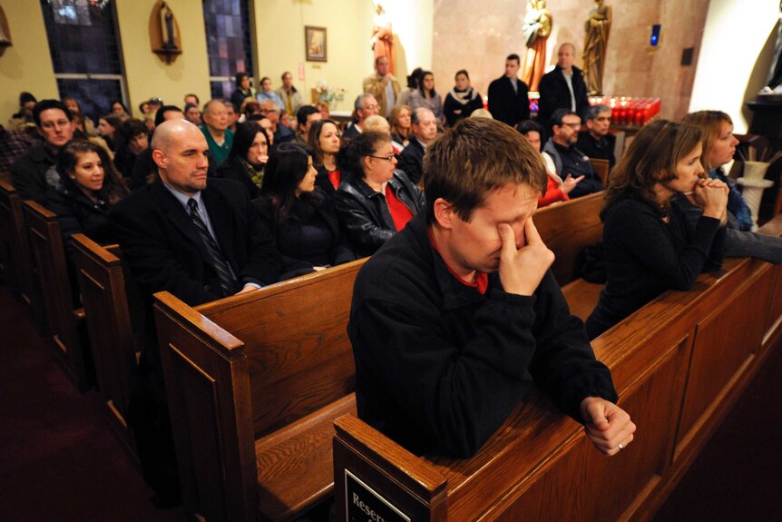 Mourners gather inside the St Rose of Lima Roman Catholic Church at a vigil service for the victims.